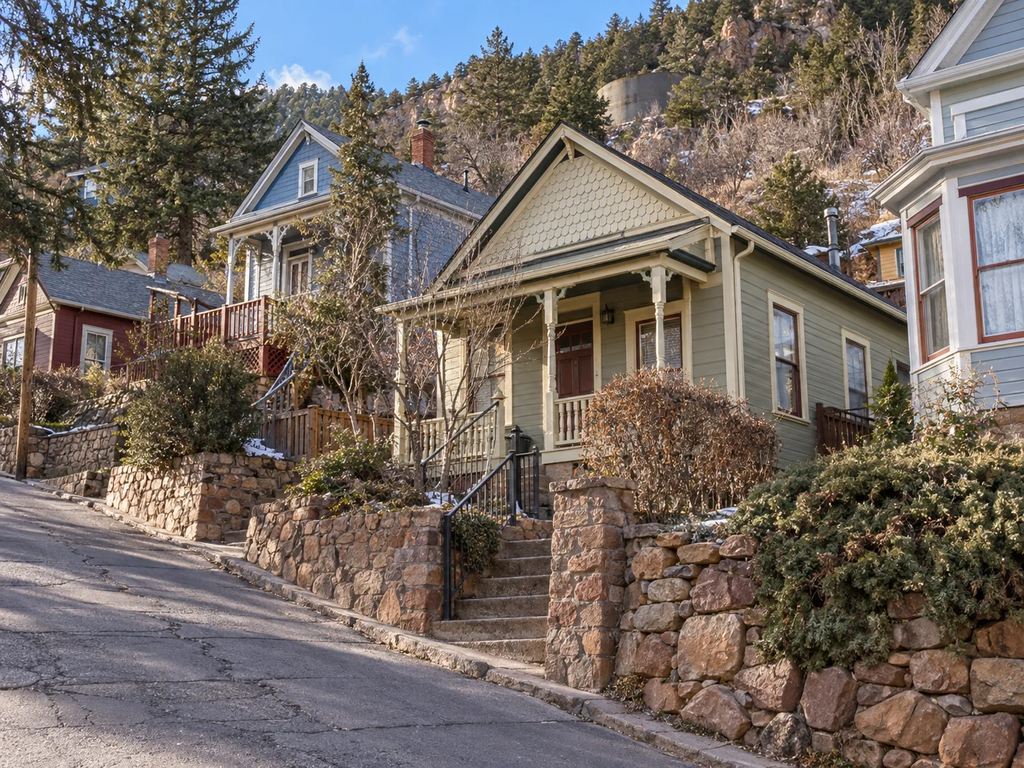 Small historic Manitou Springs homes on a steep foothill street below Mount Manitou